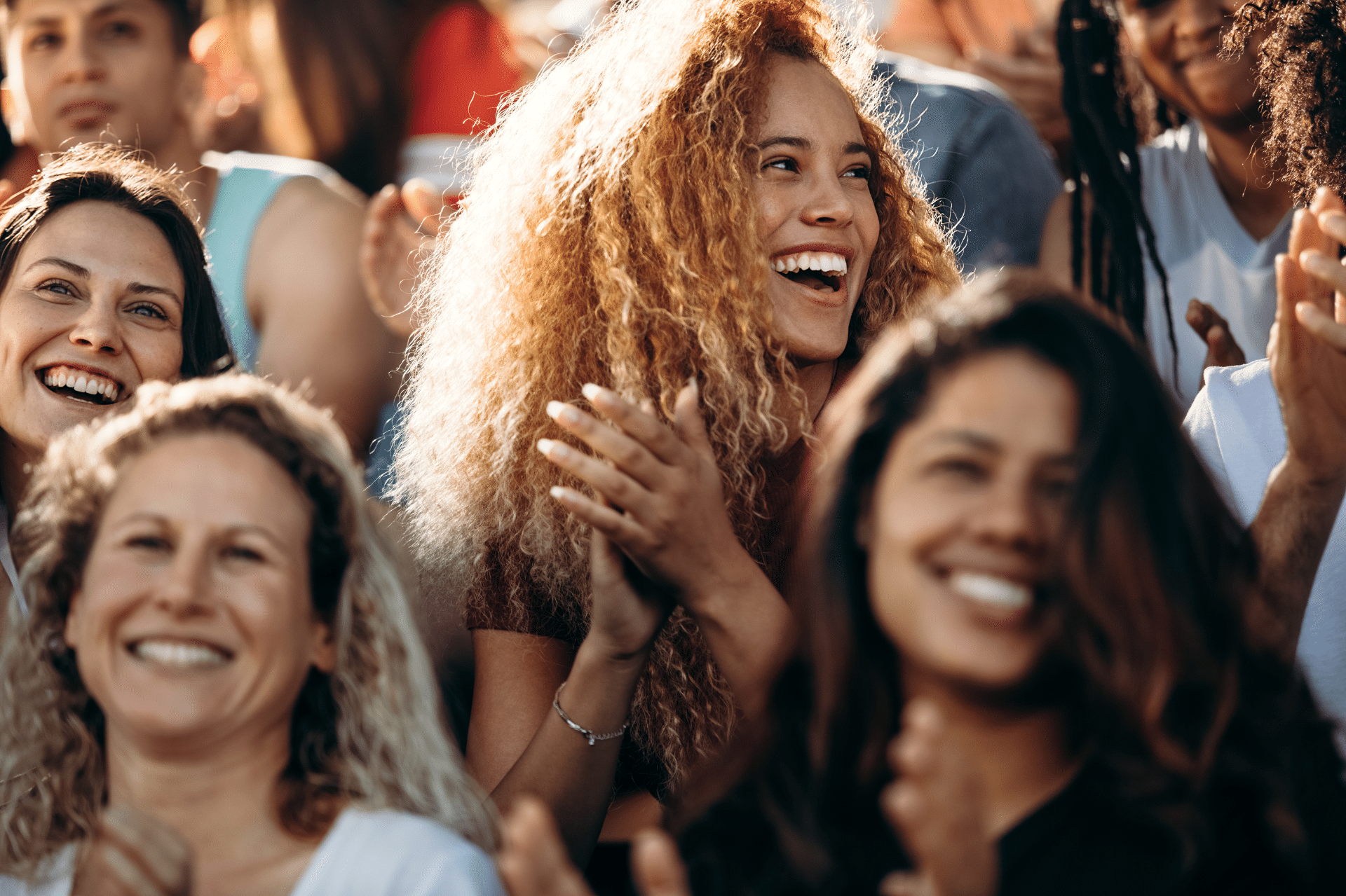 Crowd at an entertainment venue smiling and clapping